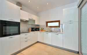 een witte keuken met witte kasten en een raam bij 3 Bedroom Cozy Home In Vinica in Vinica