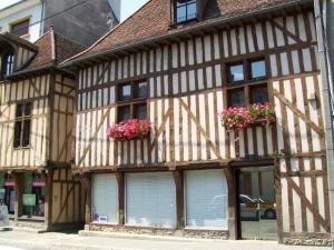 an old building with flowers in the windows at Le Clos Saint Nizier in Troyes