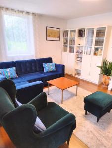 een woonkamer met een blauwe bank en een tafel bij GreenHill House in Kaunas