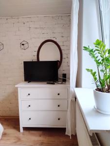 een slaapkamer met een witte dressoir met een spiegel bij GreenHill House in Kaunas