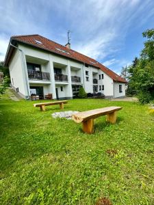 deux bancs dans l'herbe devant un bâtiment dans l'établissement Vincent, à Luhačovice