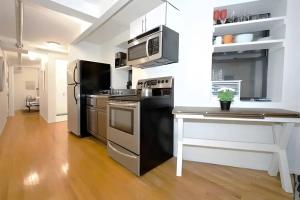 纽约For Rent in Chelsea Your Ideal Space Awaits l Cardi l的厨房配有不锈钢用具,铺有木地板