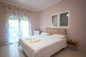 a bedroom with a white bed with a towel on it at Blu Horizon Hotel Gjipe in Dhërmi