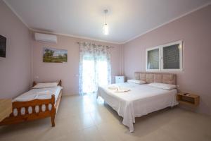 a bedroom with two beds and a window at Blu Horizon Hotel Gjipe in Dhërmi