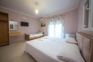 a bedroom with a large white bed and a window at Blu Horizon Hotel Gjipe in Dhërmi