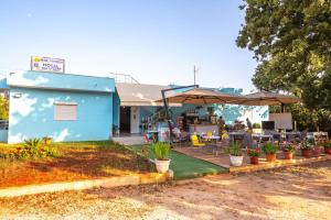 a blue building with tables and chairs and umbrellas at Blu Horizon Hotel Gjipe in Dhërmi