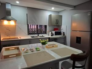 a kitchen with a white counter and a refrigerator at Luxury Apartment 150 m from the beach in Flic-en-Flac