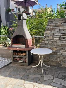 een pizza-oven met een tafel en een tafel bij Casa Olympou 15 in Iraklitsa