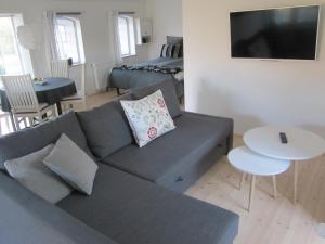 sala de estar con sofá gris y cama en Tåsinge B&B, en Svendborg