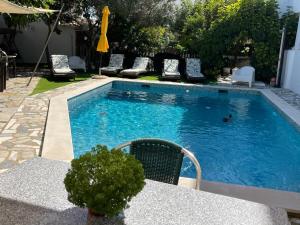 una piscina con sillas y una mesa con en Ria Studios, en Olhão