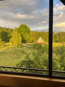 una finestra con vista su un campo e su una casa di Садиба Карпат a Verkhovyna