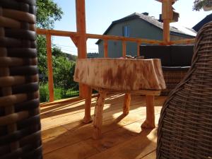 a wooden table on a deck with a view of a house at B&B Le bruissement in Bièvre