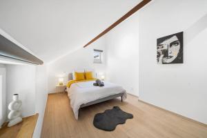 Habitación blanca con cama y alfombra en Le Duplex Moutarde, en Chalon-sur-Saône