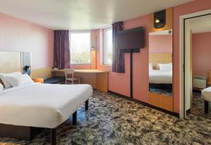 una camera d'albergo con letto e scrivania di B&B HOTEL Orly Rungis Aéroport 3 étoiles a Rungis