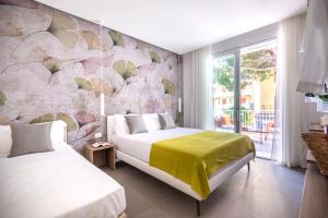 two beds in a bedroom with a wall mural at Residence Lido di Dante in Lido di Jesolo