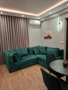 a living room with a green couch and a table at Vila Noar in Vlorë