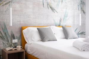 a bedroom with a bed with white sheets and pillows at Residence Lido di Dante in Lido di Jesolo