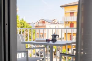 a pair of glasses sitting on a table on a balcony at Residence Lido di Dante in Lido di Jesolo