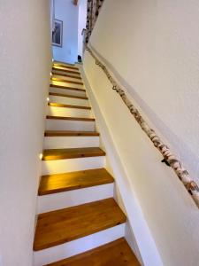 eine Treppe in einem Haus mit weißen und Holzböden in der Unterkunft Ferienwohnung Straußenblick Dachgeschoss in Bad Fallingbostel