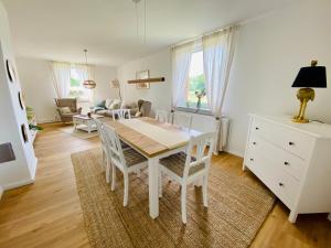 a white dining room table and chairs in a living room at Ferienhaus Straußenblick in Bad Fallingbostel