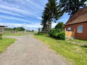 a dirt road next to a brick house at Ferienhaus Straußenblick in Bad Fallingbostel