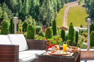 une table avec une assiette de nourriture et un verre de jus d'orange dans l'établissement Hotel Yastrebets Wellness & Spa, à Borovets