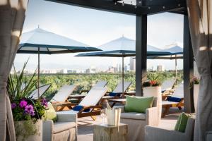 una fila di sedie e ombrelloni su un patio di Halcyon - A Hotel in Cherry Creek a Denver