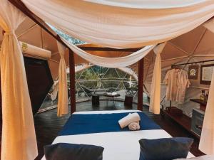 pokój z łóżkiem w namiocie w obiekcie Domus Glamping Guatapé w mieście Guatapé