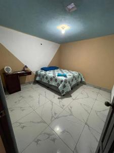 um quarto com uma cama e piso em azulejo em Casa Julia Xela em Quetzaltenango