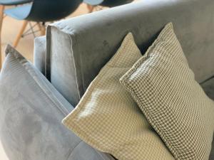 two pillows sitting on top of a gray couch at PROMO PRICE - Colorful by the sea - 1 min from the beach in Durrës