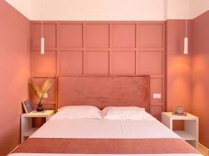 a bedroom with a large bed with pink walls at PROMO PRICE - Colorful by the sea - 1 min from the beach in Durrës