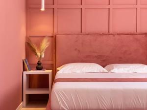 a bedroom with a white bed and a pink wall at PROMO PRICE - Colorful by the sea - 1 min from the beach in Durrës