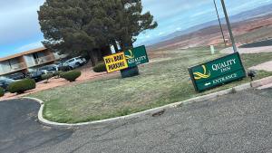 dos señales a un lado de una carretera al lado de un edificio en Quality Inn View of Lake Powell - Page, en Page