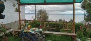 una mesa en un jardín con vistas al agua en Amantani Resorts, en Estanciasuyo