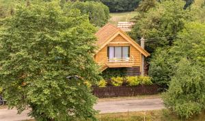 une maison en bois avec une clôture devant elle dans l'établissement Góra Jabłek Mazury Mikolajki, à Lipowo