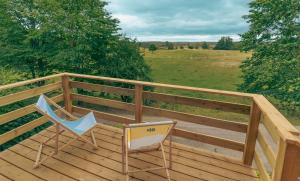 une chaise assise sur une terrasse en bois avec une clôture dans l'établissement Góra Jabłek Mazury Mikolajki, à Lipowo