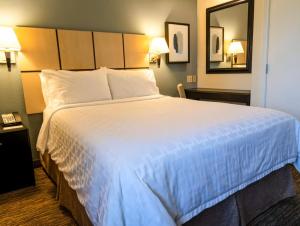 Кровать или кровати в номере Candlewood Suites East Lansing, an IHG Hotel