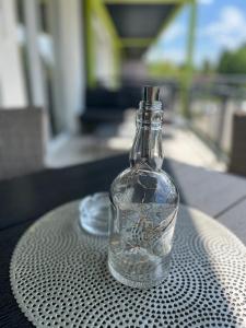 eine Glasflasche auf einem Tisch in der Unterkunft Ale Apartman Siófok in Siófok