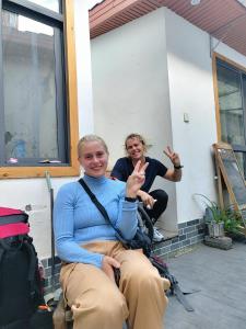 two women sitting in a chair with their hands up at Zhangjiajie Tingyutang Little Yard in Zhangjiajie