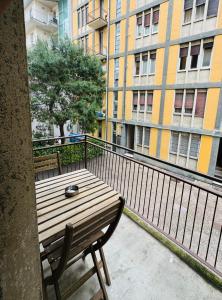 einen Holztisch und Stuhl auf einem Balkon mit Gebäuden in der Unterkunft Tiny & Cosy Studio Flat in Como in Como