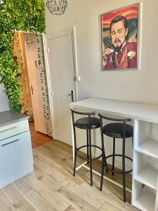 une cuisine avec une table et deux tabourets dans l'établissement Appartement cosy LYON, à Villeurbanne