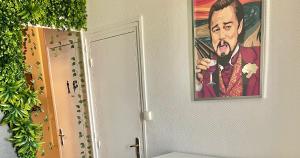 une peinture d'un homme sur un mur à côté d'une salle de bains dans l'établissement Appartement cosy LYON, à Villeurbanne