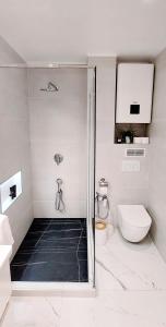 y baño blanco con ducha y aseo. en Apartman Family, en Crikvenica