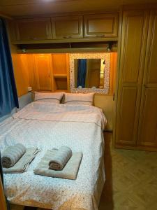 a bedroom with a bed with two towels on it at Tomiceva Koliba Rtanj 4 in Rtanj