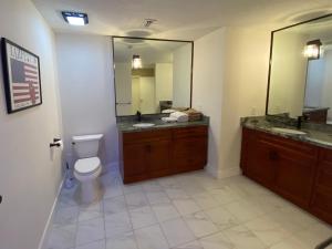 La salle de bains est pourvue de toilettes, d'un lavabo et d'un miroir. dans l'établissement Riverbank Guesthouse Wilton Manors, à Fort Lauderdale