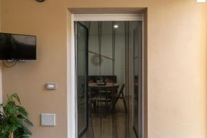 una porta che conduce a una sala da pranzo con tavolo di La vela bianca ad Alghero