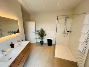 a bathroom with two sinks and a shower at COZY, neue 3 Zimmer Ferienwohnung Goslar Altstadt in Goslar