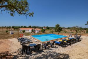 uma grande piscina com cadeiras e uma mesa em Valle D`Água - Casas de campo em Vale de Água