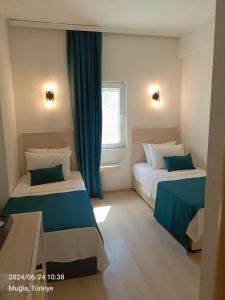 um quarto de hotel com duas camas e uma janela em Mia Hill Suites em Bodrum City