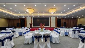 een feestzaal met witte tafels en stoelen en een scherm bij Holiday Inn Express Chengdu Tianfu Square by IHG - Chunxi Road and Kuanzhai Alley in Chengdu